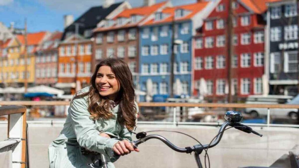Denmark tourist spots, cycling paths near colorful Nyhavn harbor houses