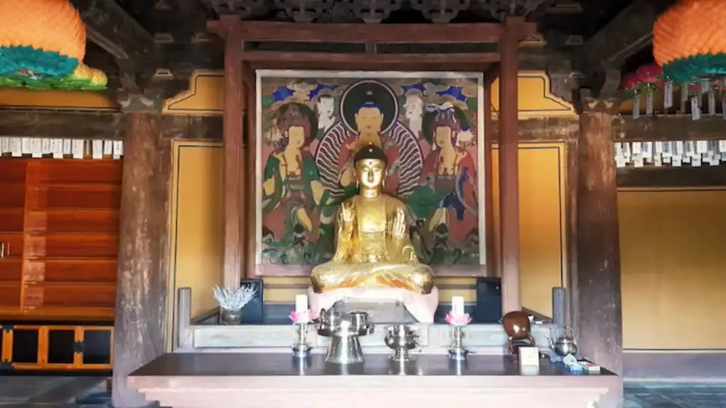 Andong vs Gyeongju golden Buddha statue at Bongjeongsa Temple in Andong with colorful mural painting and traditional altar offerings