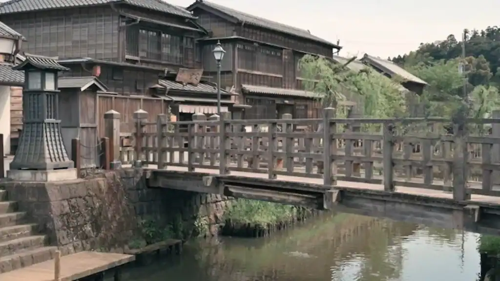 Historic wooden lattice bridge crossing canal with traditional merchant houses in Sawara, Japan