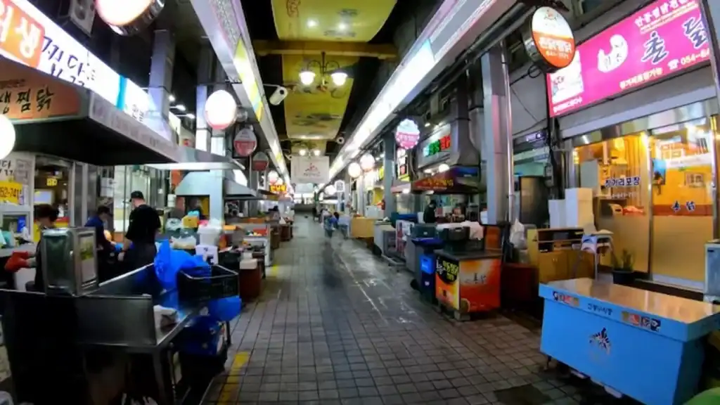 Andong Jjimdak restaurants at Andong Old Market indoor alley with colorful storefronts Korean signage and traditional food stalls lining walkway