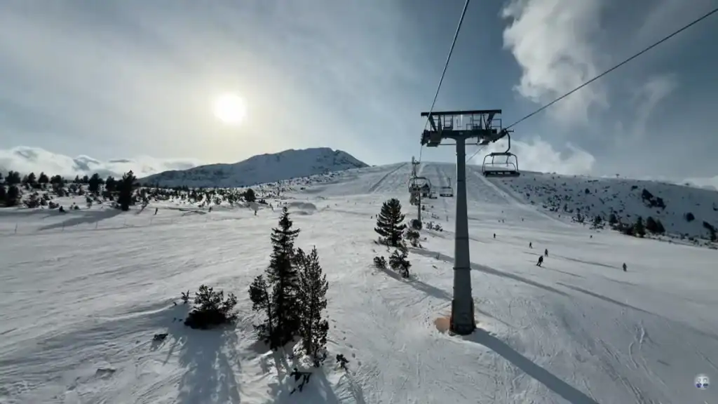 Bansko year round ski resort with chairlift and snow-covered slopes in winter sunshine