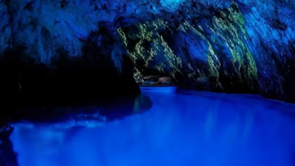 Blue cave tour showing luminous blue water and rock formations inside grotto