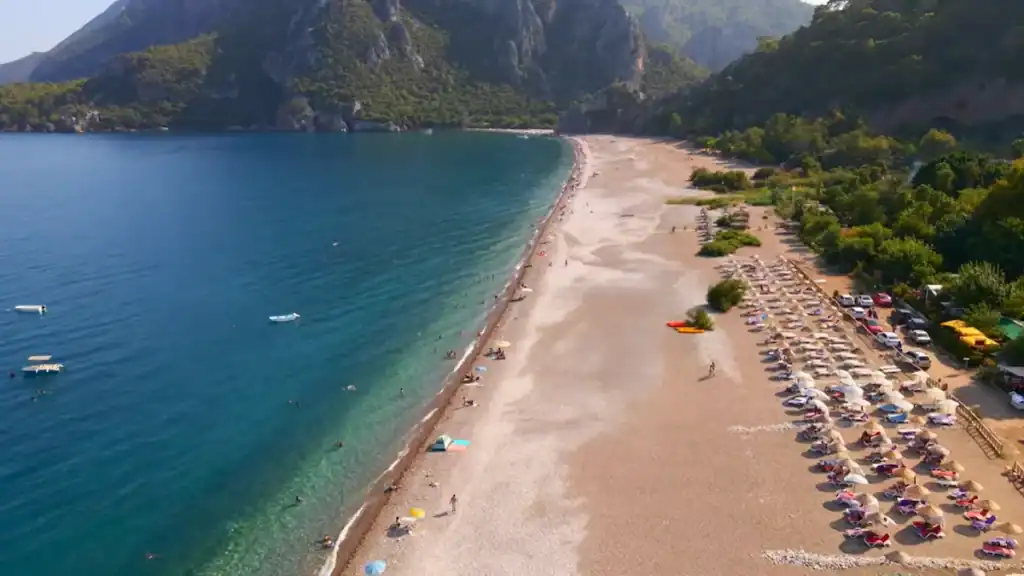 Çıralı beach aerial view showing pristine pebble shoreline with turquoise waters and dramatic mountain backdrop