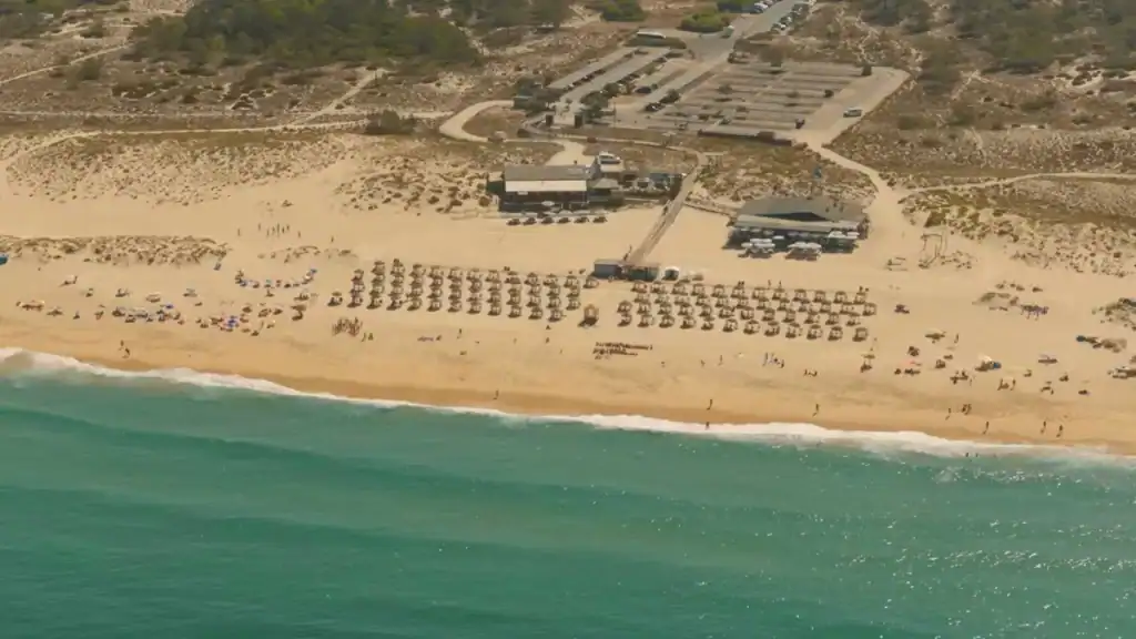 Aerial view of Comporta beach with turquoise waters golden sand and beachfront facilities