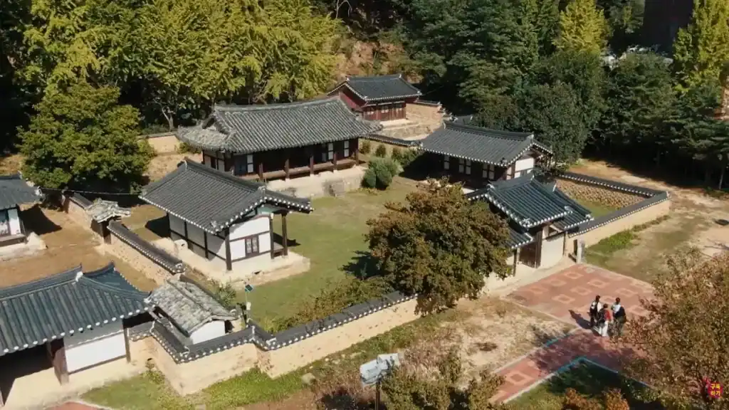 Aerial view of Confucian Academy complex with traditional tile roofed buildings courtyard and surrounding forest landscape