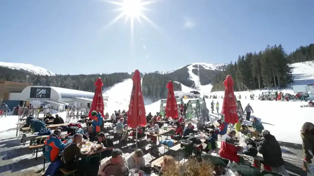 Bansko digital nomad enjoying sunny slopes with outdoor dining and mountain views
