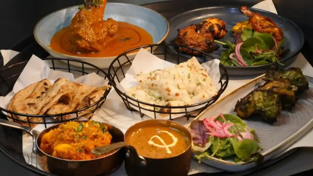 Indian cuisine from Kachori with curry, tandoori, naan, and vegetable dishes