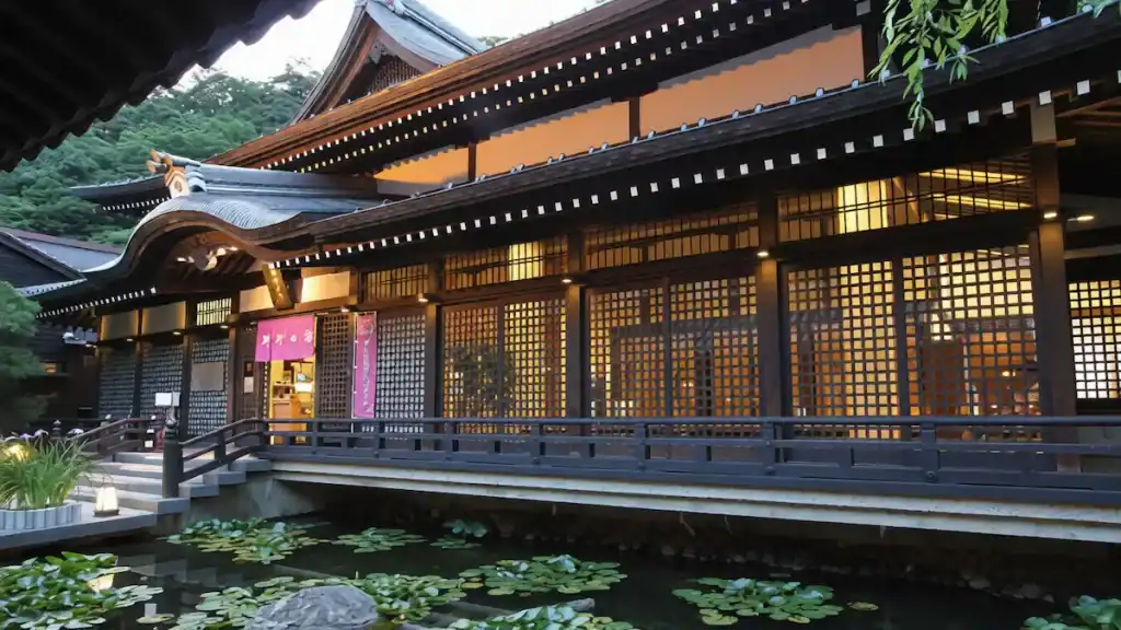 Kinosaki day trip - Goshono Yu bathhouse with wooden bridge over tranquil koi pond in Kinosaki
