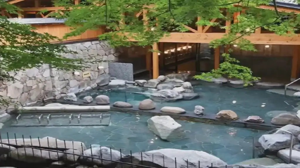 is Kinosaki Onsen worth it - Goshono Yu outdoor hot spring bath with natural rocks and lush greenery