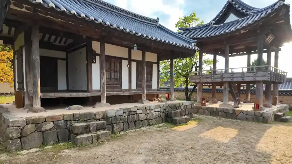 Andong Hahoe Village traditional Korean hanok houses with curved tile roofs wooden pillars stone walls and elevated pavilion in courtyard