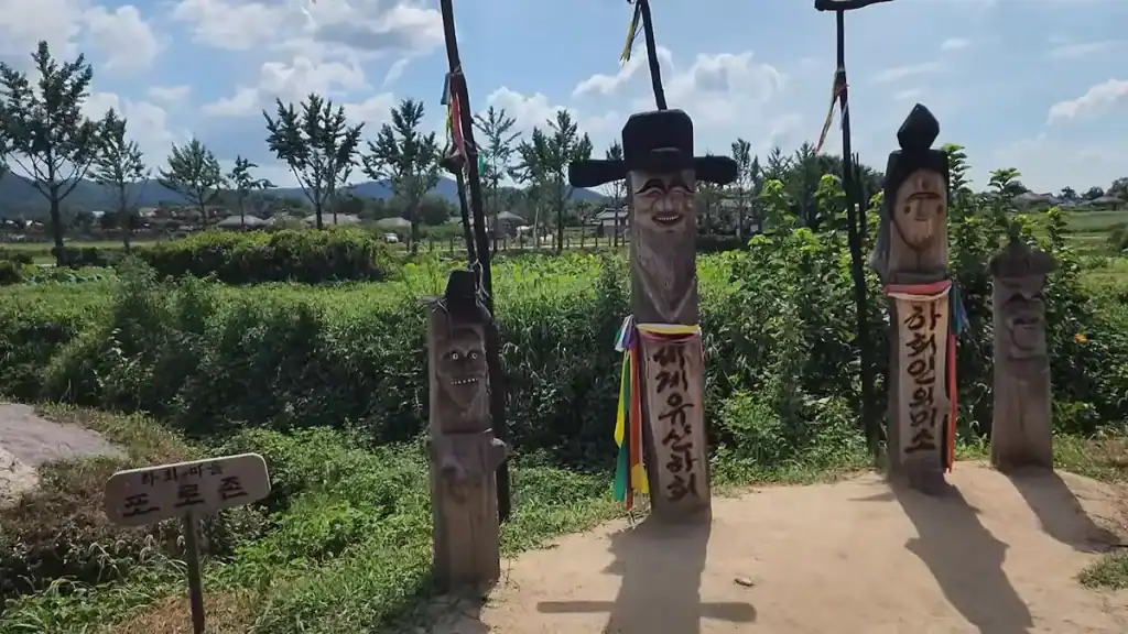 Things to do in Andong traditional wooden guardian posts at Hahoe Folk Village with carved faces Korean inscriptions and colorful ribbons