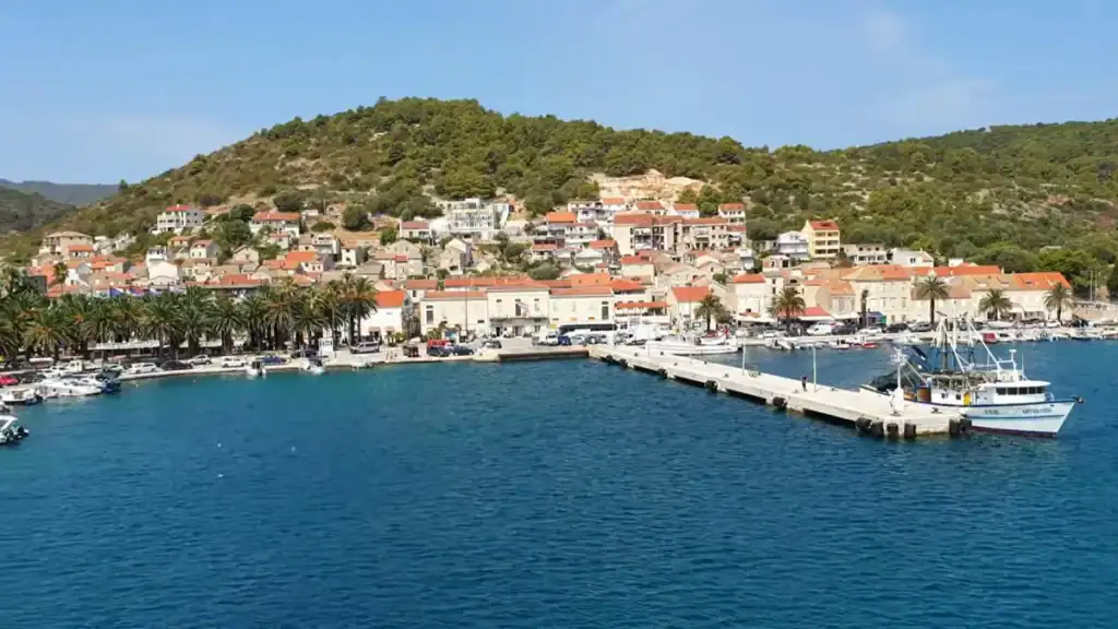 Vis Town vs Komiza harbour showing pier with boats and hillside settlement