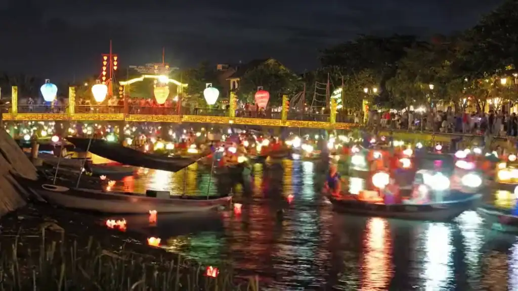 Hoi An cultural scene with illuminated lantern boats on river at night