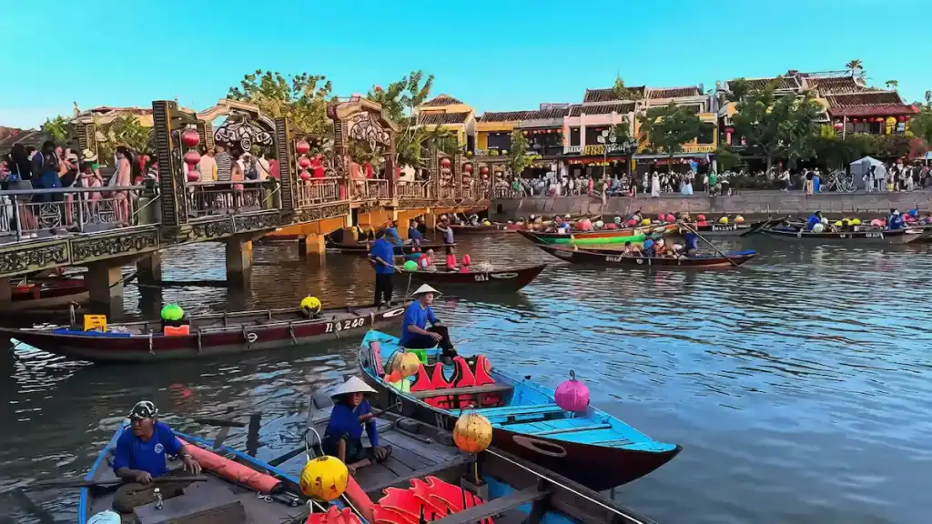 Colorful boats and iconic bridge in Hoi An Ancient Town when exploring Tam Ky vs Hoi An