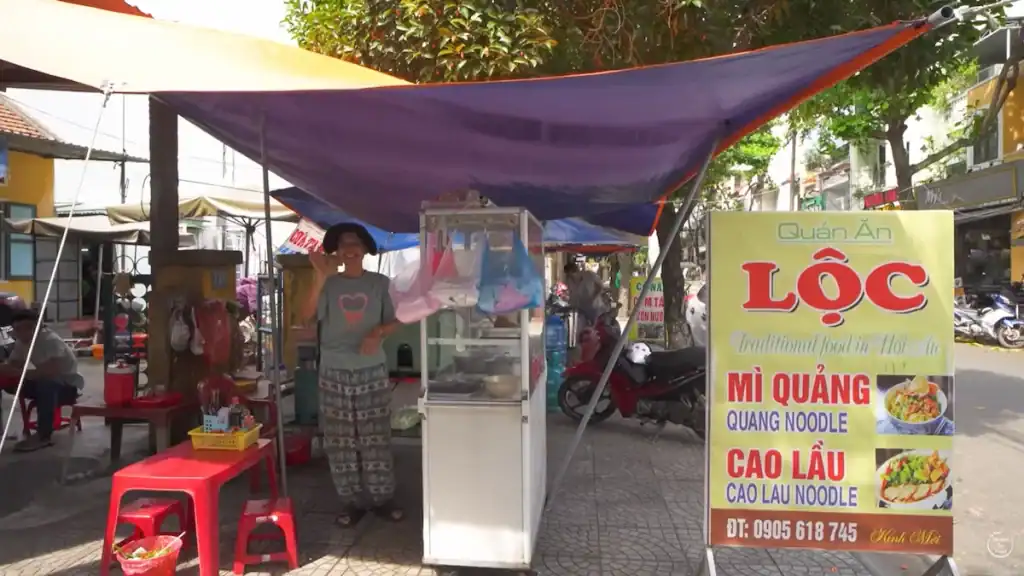 Hue street food vs Hoi An displayed at traditional food vendor stall with colorful signage