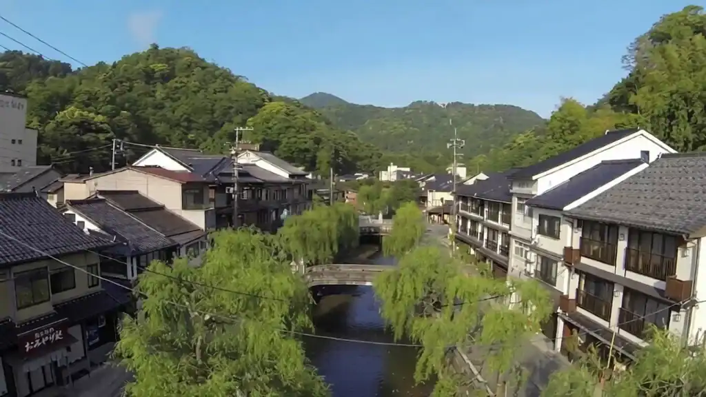 Kinosaki day trip - aerial view of canal with willow trees and traditional ryokans nestled in mountains