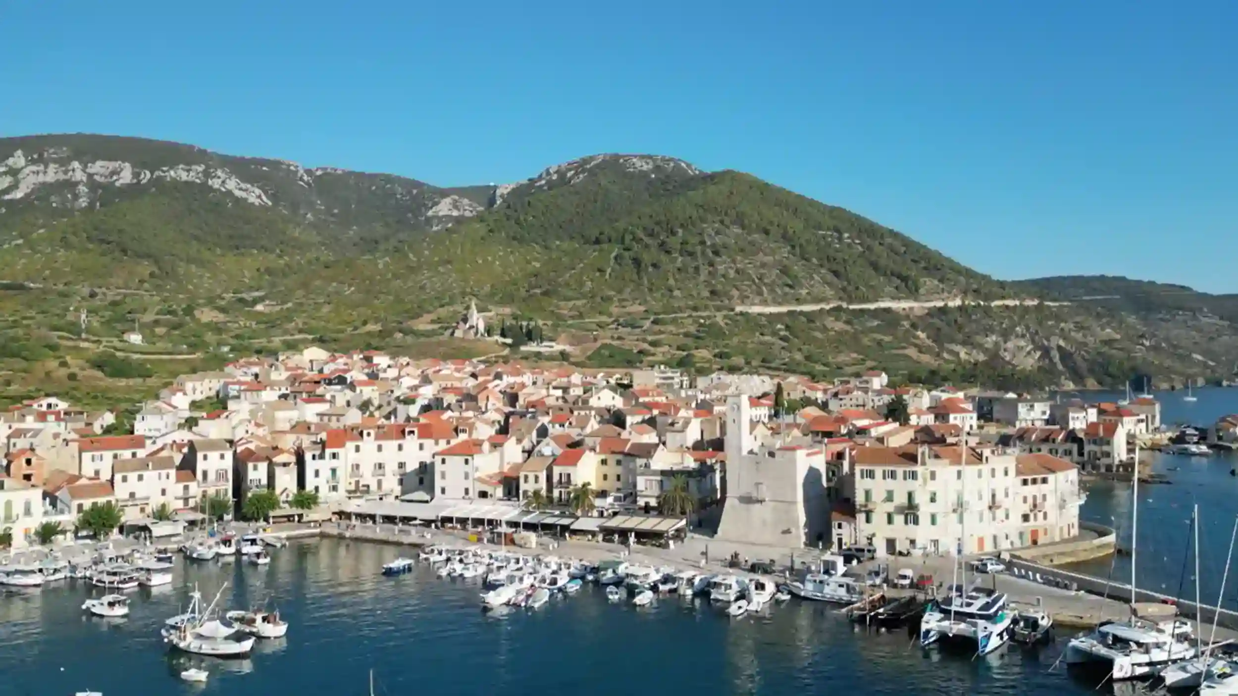 Vis Island remote work destination showing Komiza town with harbor and mountain backdrop