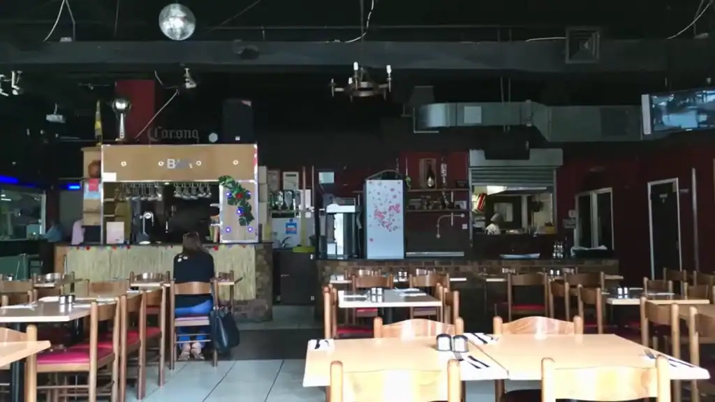 La Bodeguita dining room with wooden tables and open kitchen bar