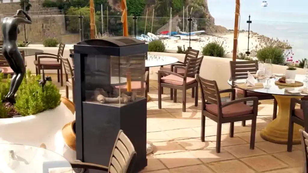 Moraira expensive beachfront restaurant terrace with elegant dining furniture and sea views.