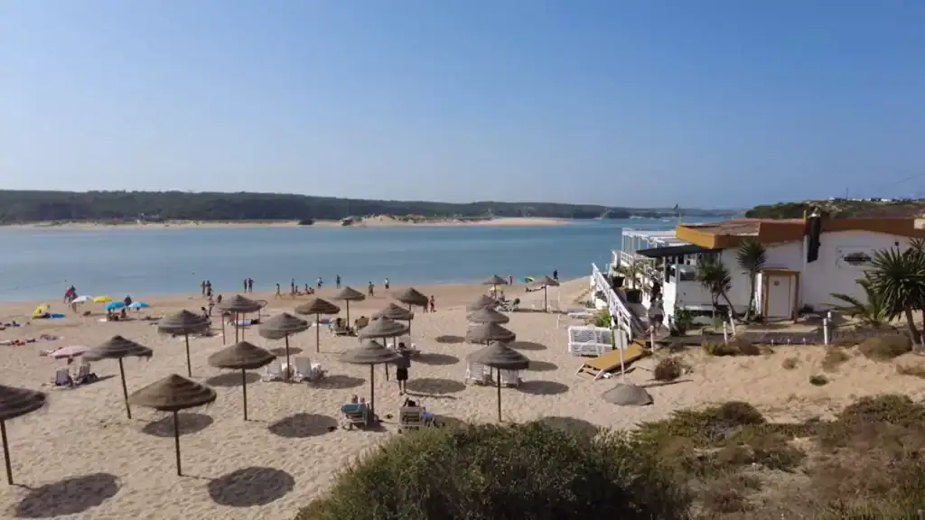 Milfontes beach area with traditional parasols calm waters and beachfront dining facilities