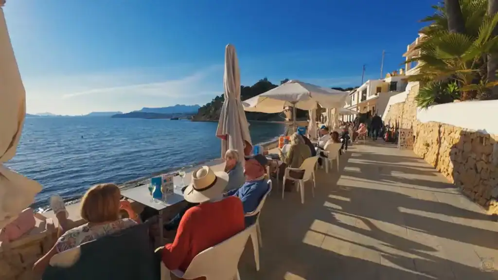 Waterfront cafe with diners enjoying sea views and coastal atmosphere.