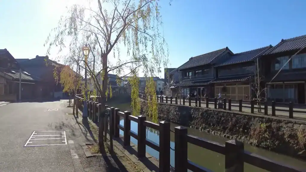Empty morning street along Sawara canal with willow trees and traditional wooden railings