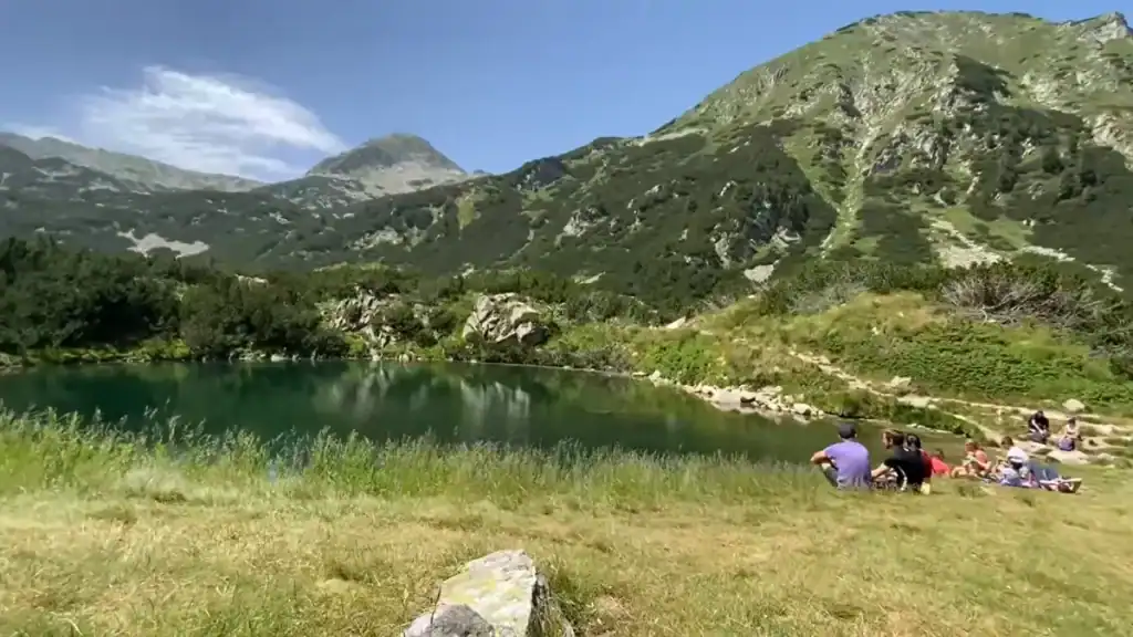 Bansko digital nomad relaxing by alpine lake in Pirin National Park with mountain views