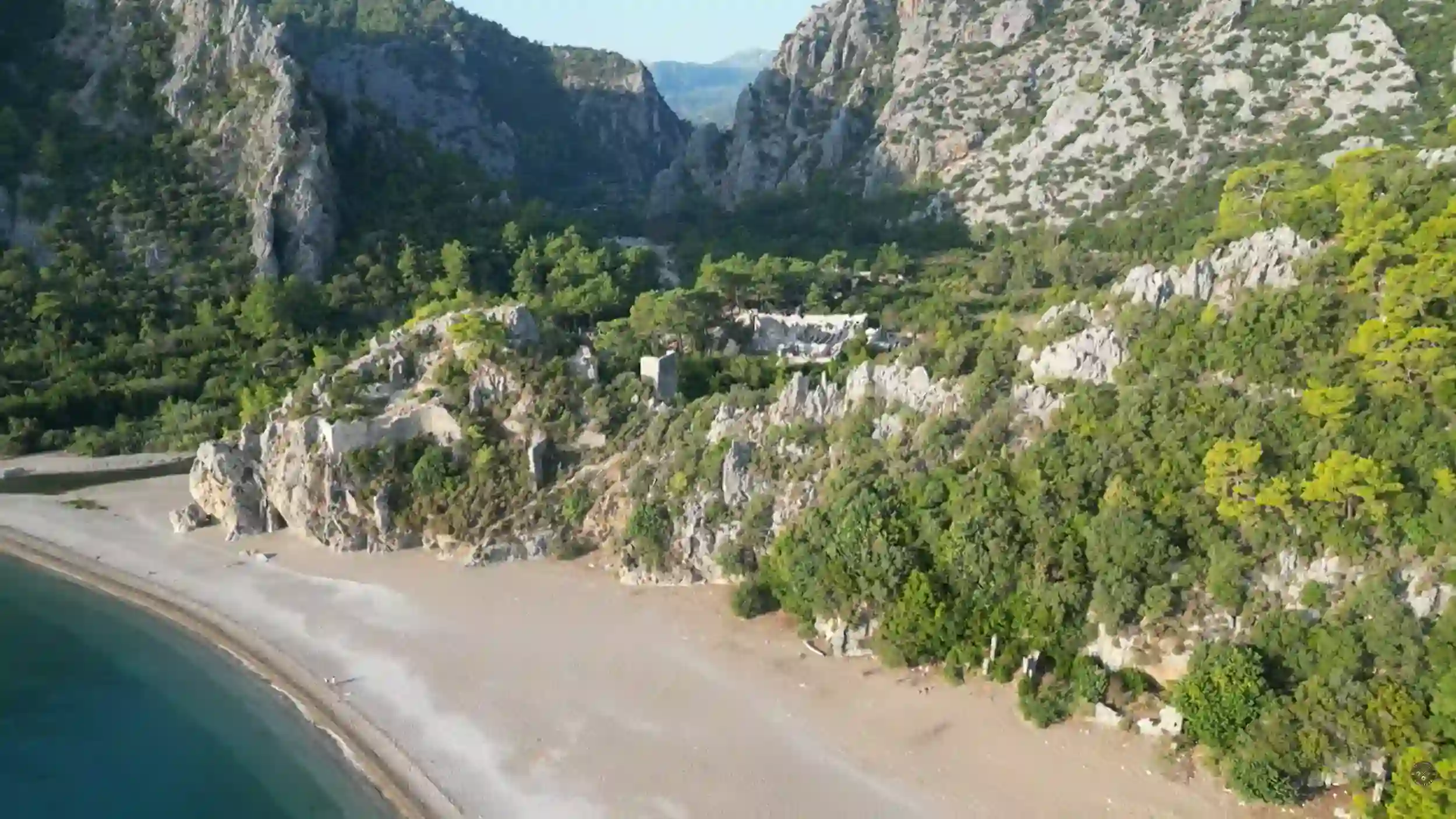 Olympos day trip Antalya beach nestled between dramatic limestone canyon walls