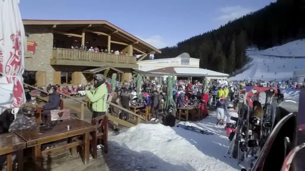 Bansko summer vs winter crowded mountain cafe with skiers and snowboards