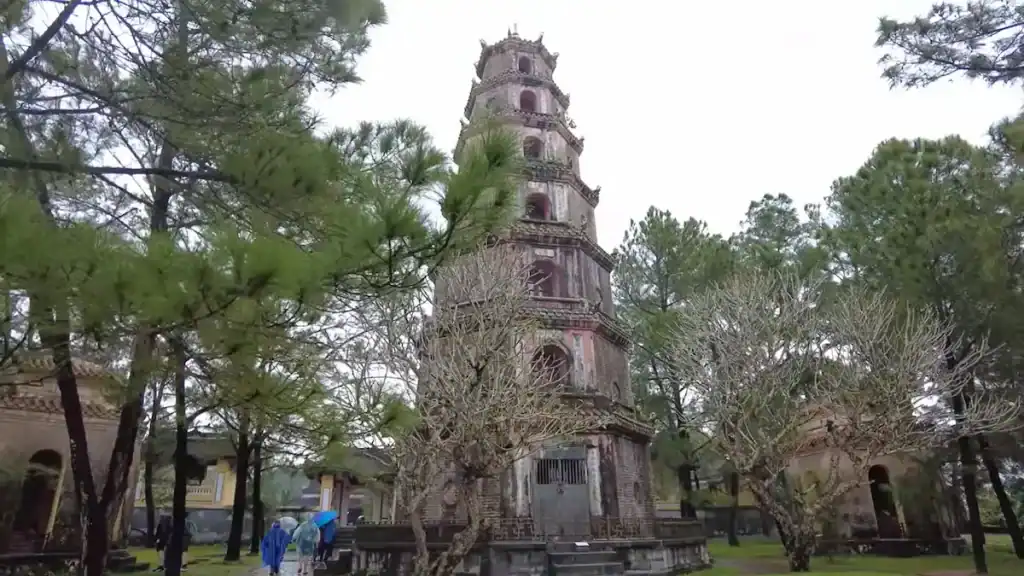 Thien Mu Pagoda tower surrounded by bare trees during Hue's rainy season
