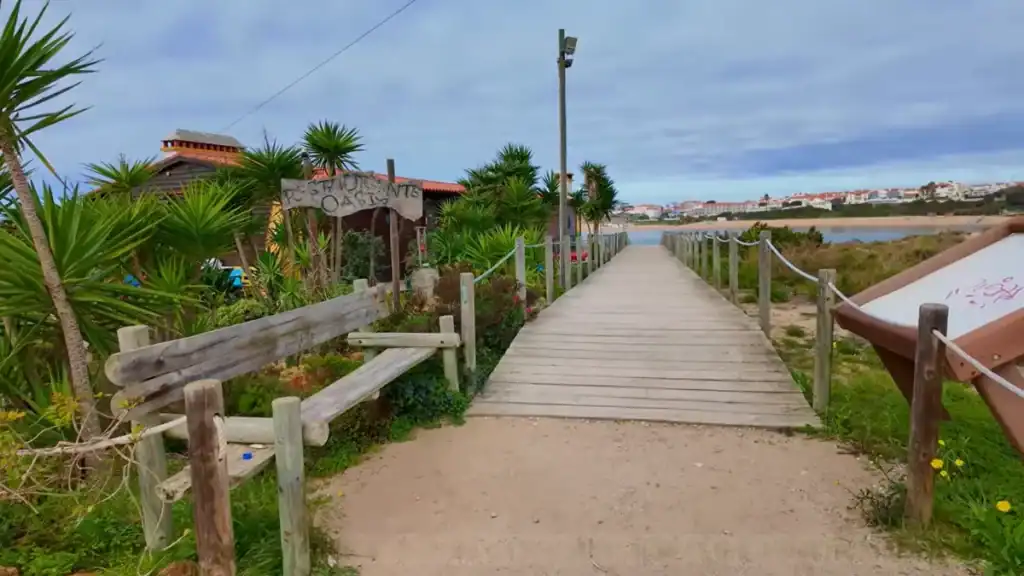 Restaurante Oasis wooden boardwalk entrance with tropical plants and riverside views