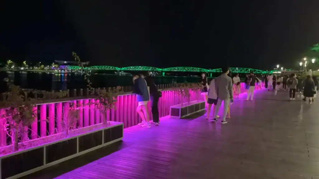 Is Hue worth visiting? The Perfume River promenade features vibrant purple lighting at night.
