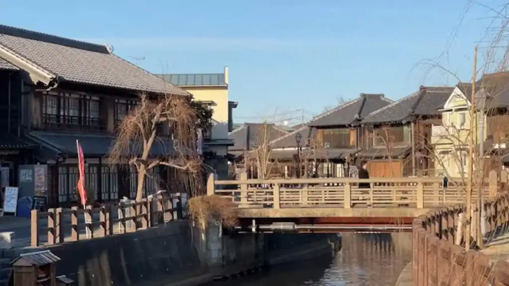 Traditional wooden bridge crossing a calm canal with historic merchant houses in Sawara, Japan