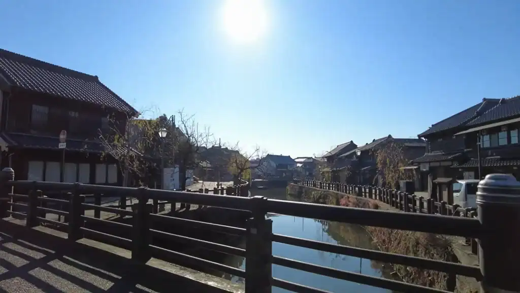 Wooden bridge crossing Sawara canal at sunrise with traditional merchant houses and quiet streets