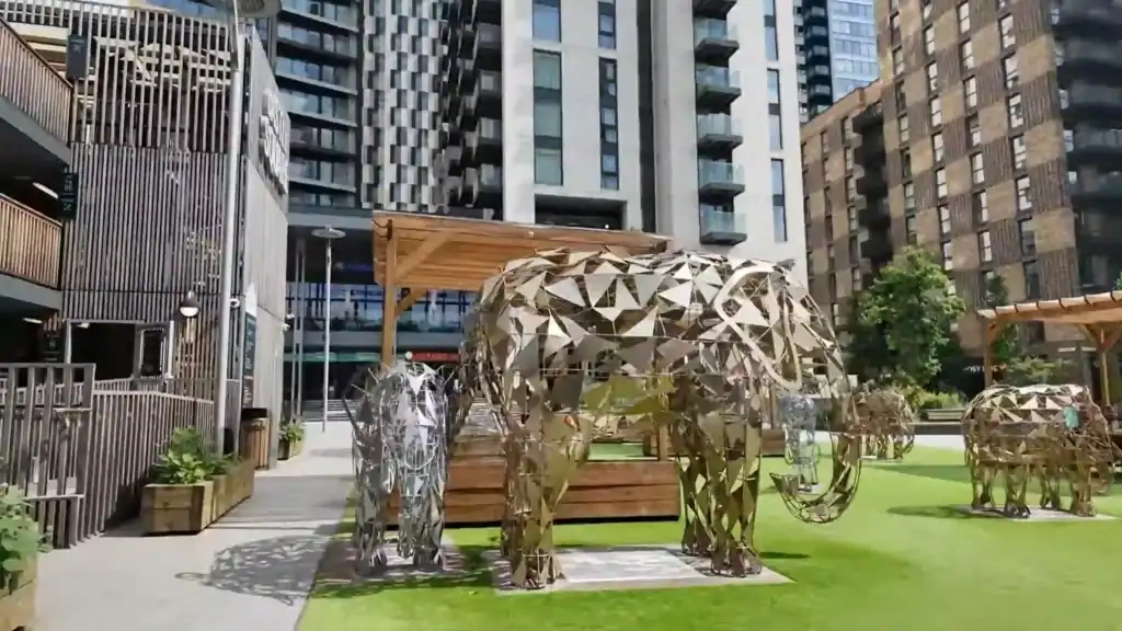 Metal elephant sculptures at Elephant and Castle in public plaza surrounded by modern residential tower blocks