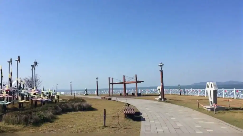 Sihwa Tidal Power Plant seawall walking path with modern sculptures, viewing platforms, and ocean panoramas under clear sky
