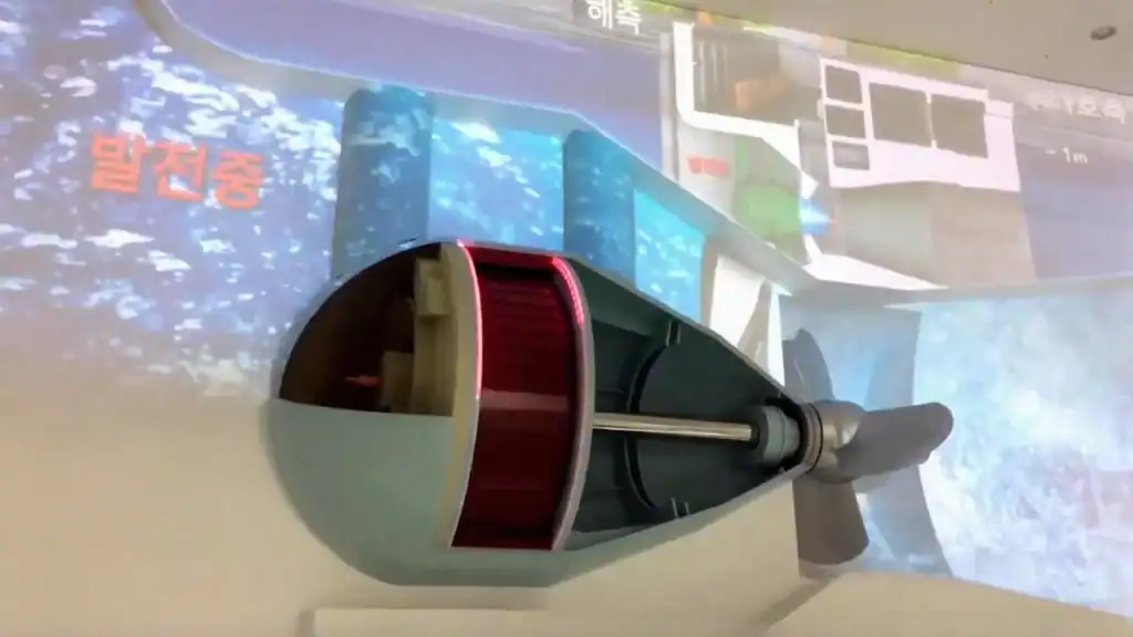 Sihwa Tidal Power Plant turbine model display showing cutaway generator with educational video screen behind at exhibition