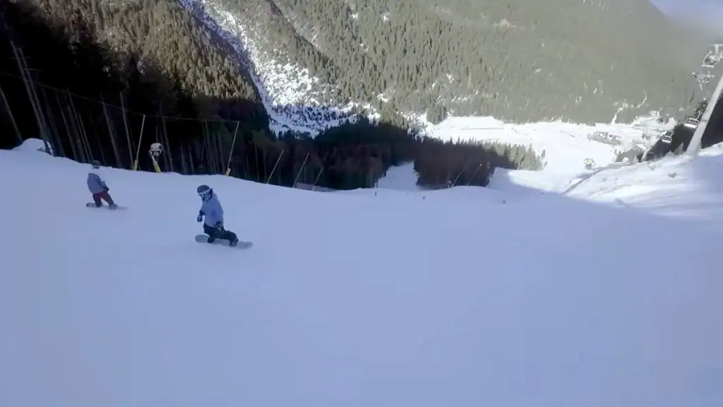 Bansko summer vs winter snowboarders descending ski slope with mountain views