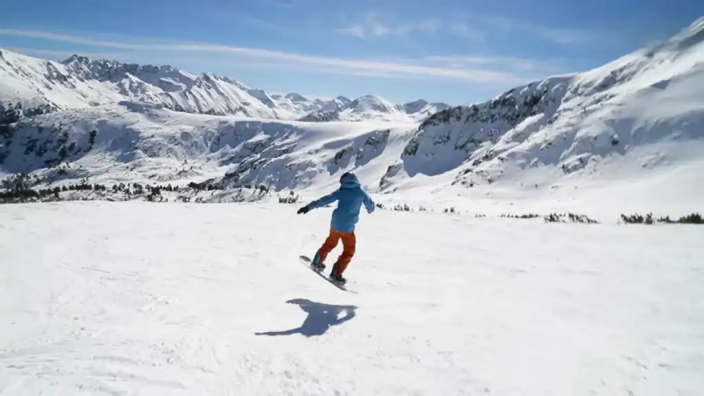Bansko summer vs winter snowboarder riding down snowy mountain slopes
