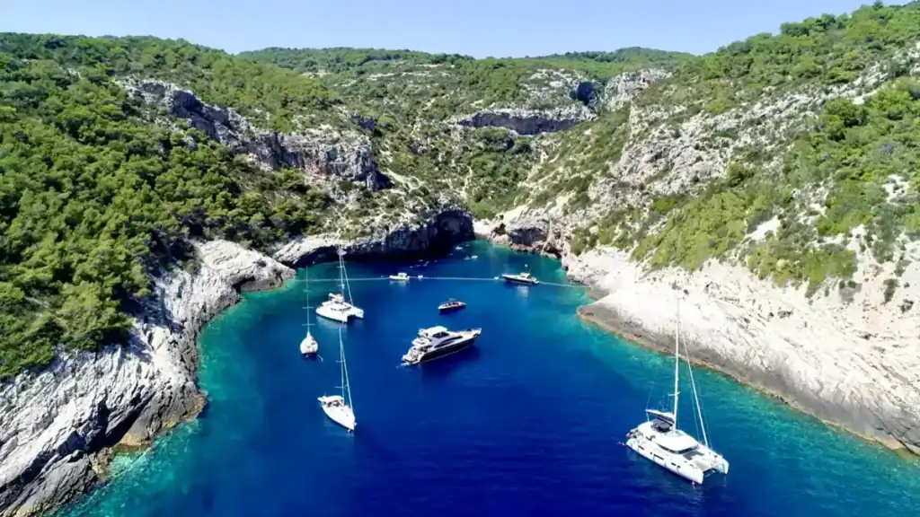 Vis Island without a car accessible Stiniva Bay with dramatic cliffs, turquoise waters, and anchored boats