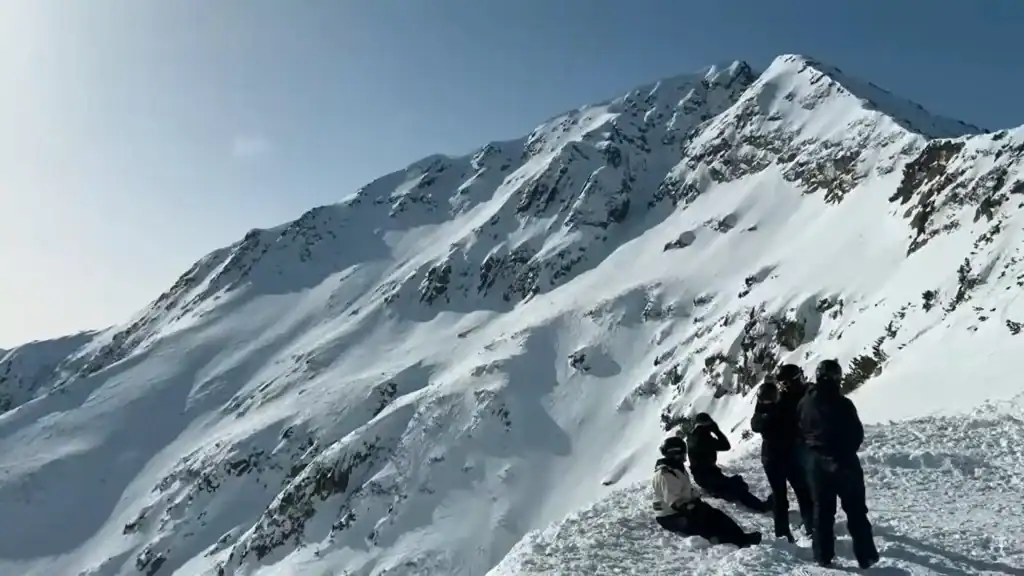 Bansko year round mountain adventures with hikers at snowy summit viewing peak