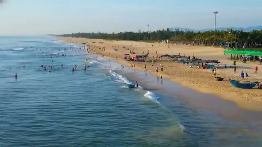 Tam Ky beach features golden sand and swimmers.