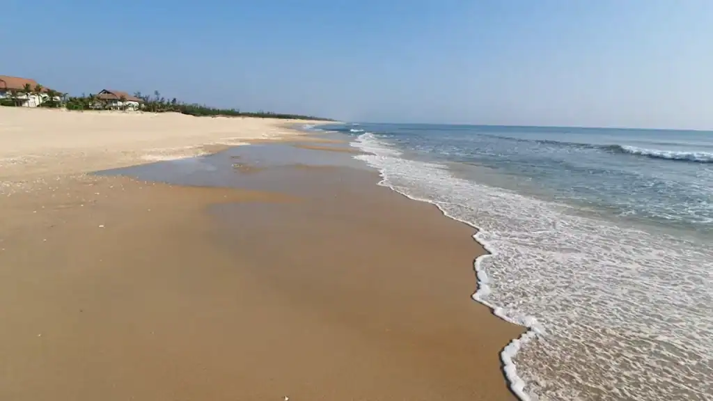 Hoi An beaches pristine Tam Thanh Beach with golden sand gentle waves and peaceful undeveloped coastline stretching ahead