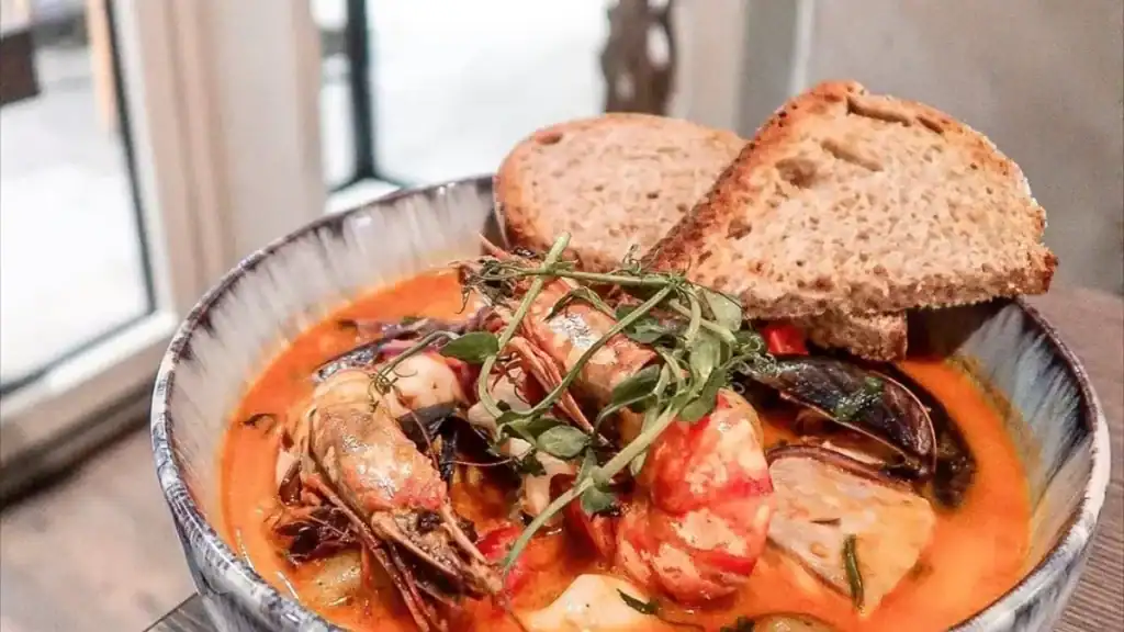 Seafood stew from Tupi serving Brazilian cuisine with prawns and bread