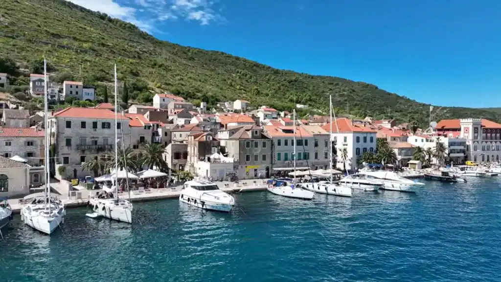 Exploring Vis Island without a car reveals charming waterfront town with colorful historic buildings and moored yachts