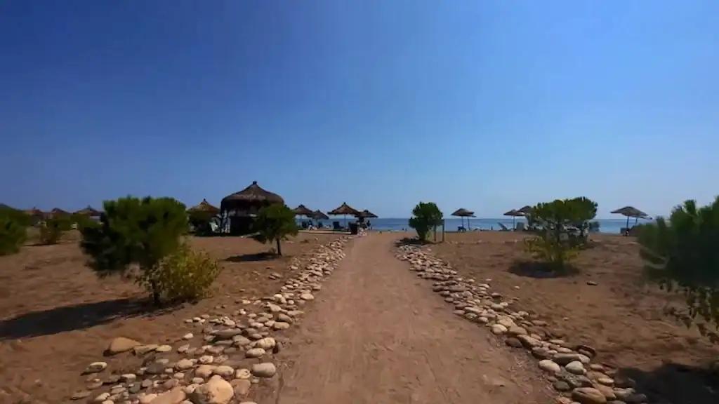 Çıralı quiet alternative pathway lined with stones leading to thatched umbrellas