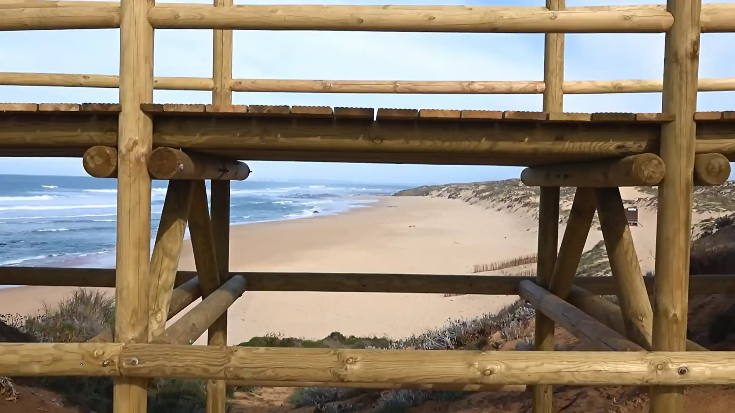 Wooden viewing platform overlooking wild sandy beach at Milfontes showing how many days to visit