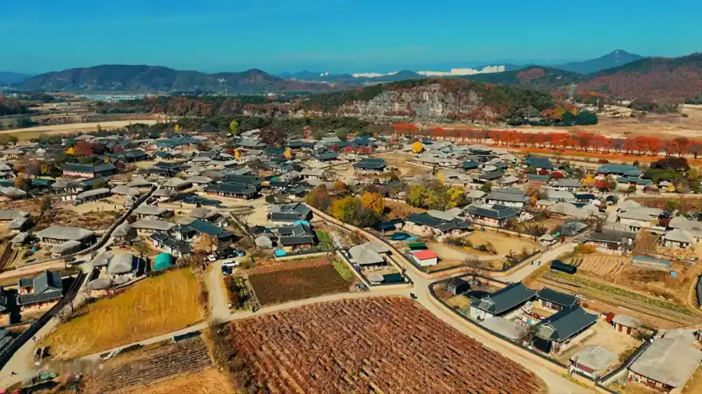 Andong vs Gyeongju aerial view of Hahoe Folk Village in Andong with traditional hanok houses autumn foliage and mountain landscape