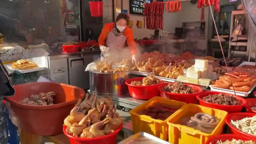 Vendor cooking fresh street food at Ansan markets with colorful dishes displayed in bowls