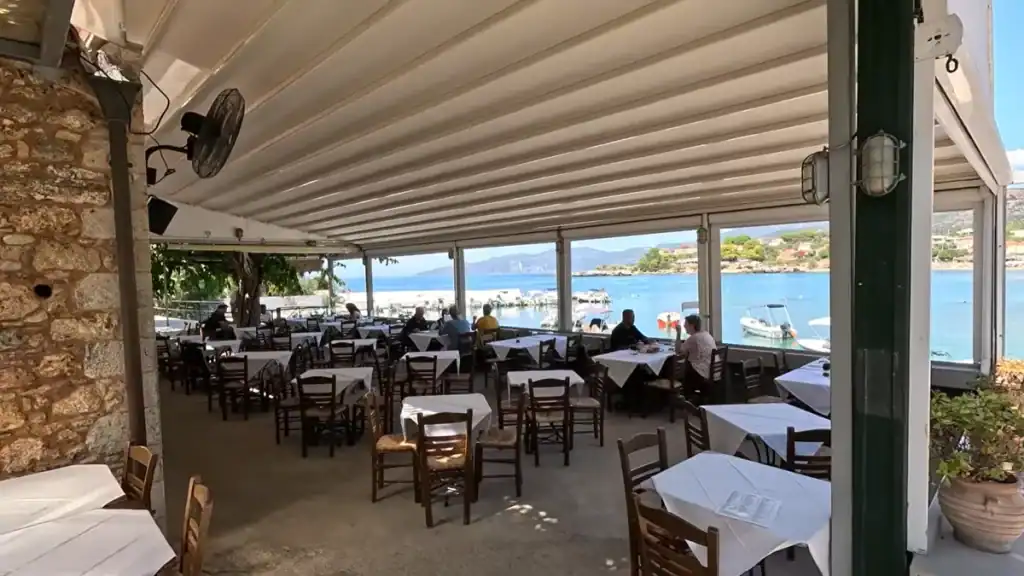 Akrogiali restaurant terrace comparing Stoupa vs Kardamyli beachfront dining with sea views.